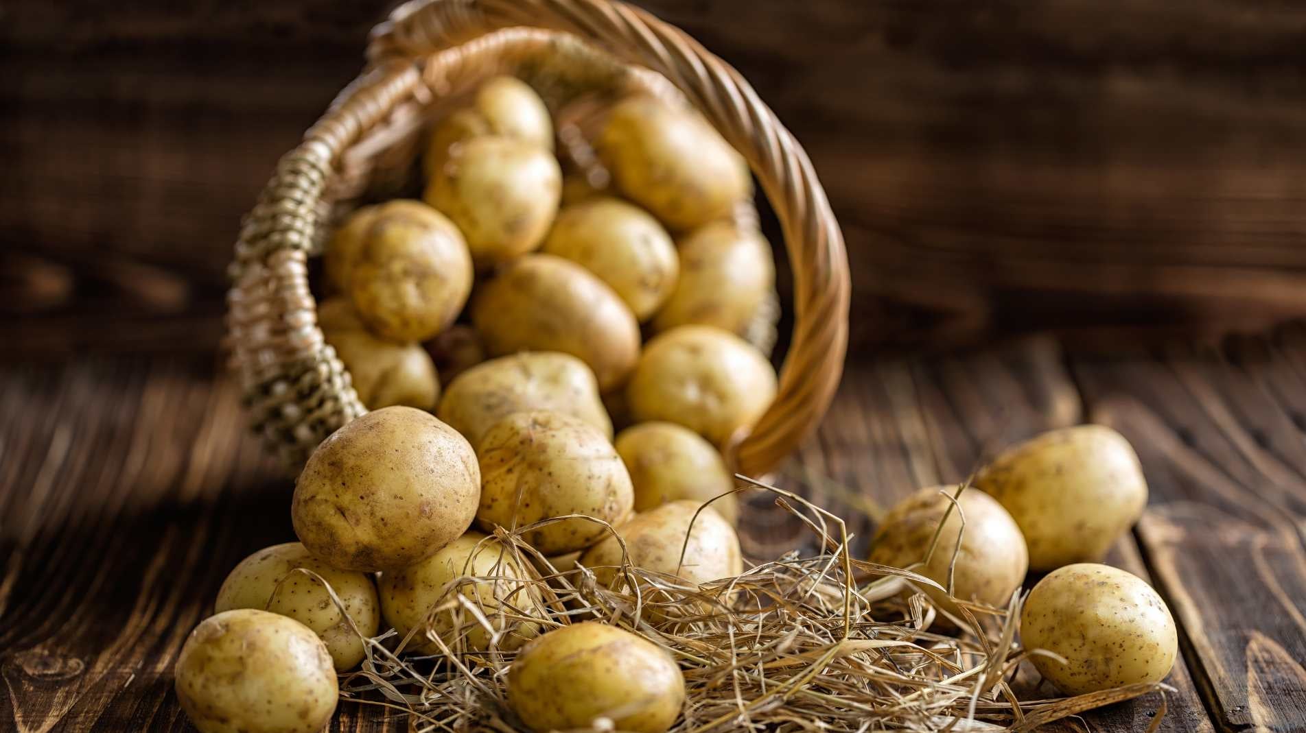 Potatoes falling out of a basket onto a wooden floor