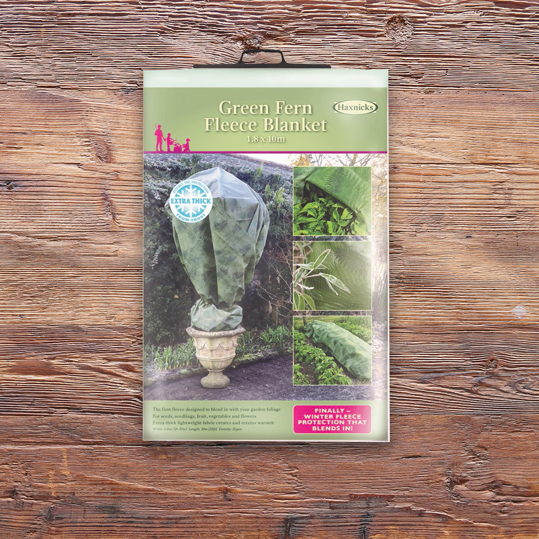 Pack shot Green Fern Fleece Blanket winter plant protection on a wooden background
