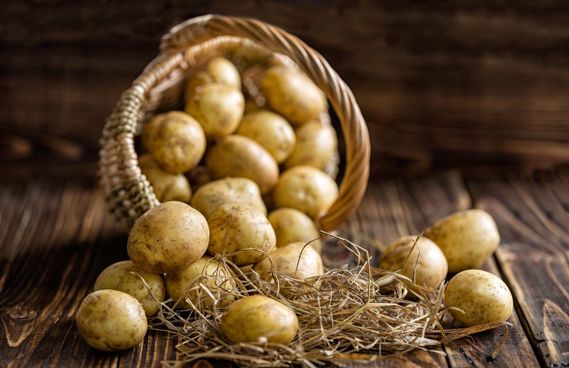 Potatoes falling out of a basket onto a wooden floor